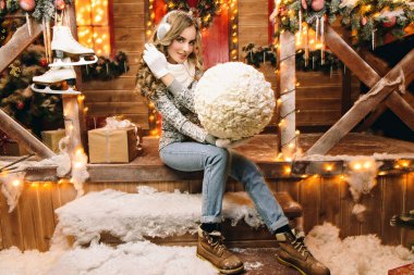 Kış giysileri güzel kızı Noel için dekore edilmiş evinin yakınındaki bir kardan adam için büyük bir kartopu yaptı. Mutlu Noeller ve mutlu yeni yıl.