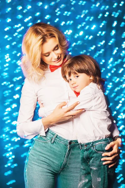 Portrait of a happy mom with her little son wearing white shirts and bow ties. Merry Christmas and Happy New Year.