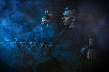 Bir vampir adam karanlık bir odada oturuyor ve şarap içme. Klasik tarzı. Güzellik, moda.