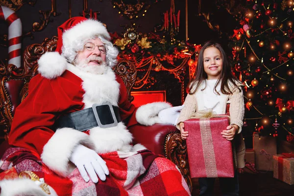 Mutlu bir genç kız Noel Baba yakınındaki bir hediye ile evde olduğunu. Mutlu Noeller ve mutlu yeni yıl.