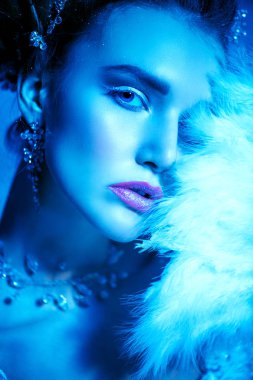 Stüdyoda mavi arka plan üzerinde poz güzel soğuk bir Bayan portresi yakından. Güzellik, kozmetik, saç modeli.