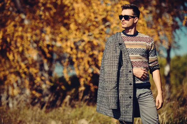 A handsome man in countryside. Autumn fashion for men. Freedom, lifestyle.