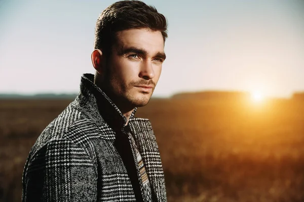 A portrait of a handsome man in countryside. Autumn fashion for men. Freedom, lifestyle.