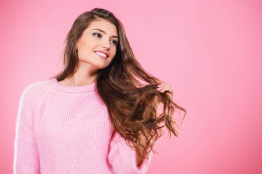 Pembe arka plan üzerinde poz güzel ve sevimli genç bir bayan. Moda, güzellik kavramı.