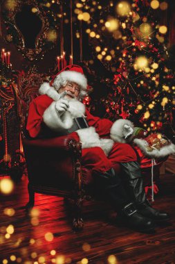 Noel Baba evinde oturan bir portresini Noel için hediye çanta yakınındaki dekore edilmiştir. Mucize zamanı. Noel, yeni yıl.