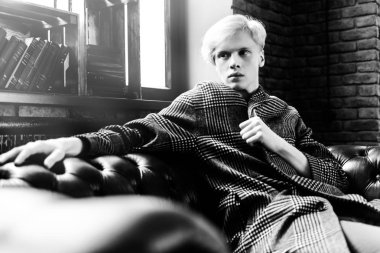 Deri koltuk üzerinde seksi yakışıklı bir adam portresi. Moda vurdu. Erkek güzelliği, moda. 