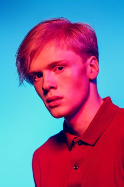 Yakın çekim portre sarışın saç stüdyoda ışık arka plan üzerinde poz ile yakışıklı bir genç adam. Erkek güzellik ve sağlık.