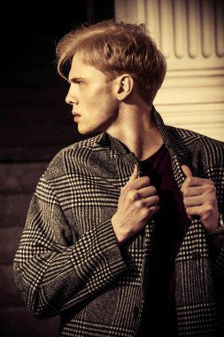 Sarı saçlı bir şehir sokakta duran bir ekose ceket giyiyor ile yakışıklı bir genç adam portresi. Erkek güzellik ve sağlık. Güzellik, şehir moda.