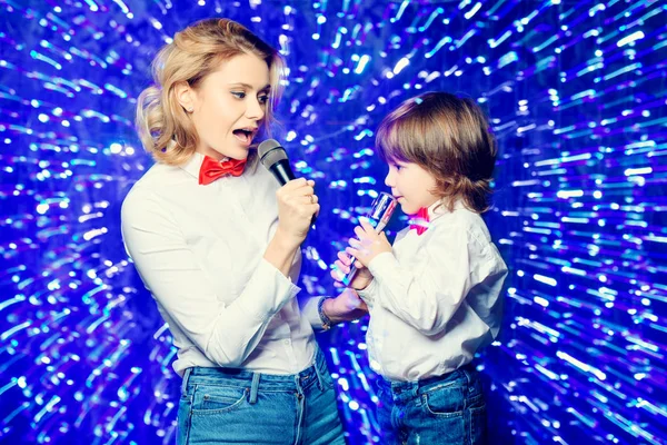 Portrait of a happy mom with her little son wearing white shirts and bow ties. Merry Christmas and Happy New Year.