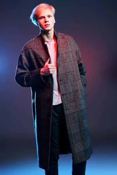 Vogue yakışıklı bir erkek model gri arka plan üzerinde kareli ceket daimi bir kadeh. Tam uzunlukta portre. Erkek güzelliği, moda. 