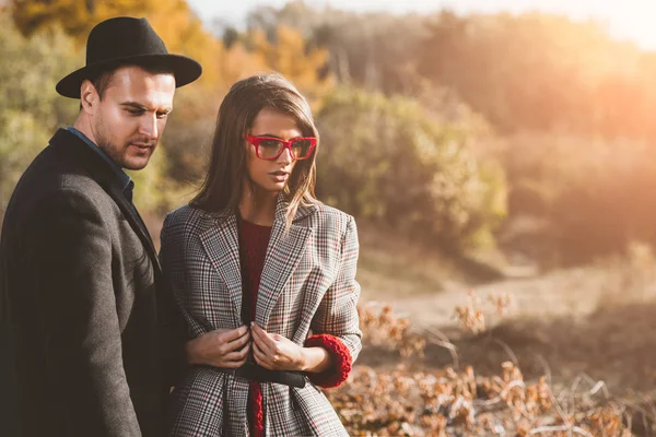 Portrait of a beautiful young people walking in the autumn park. Autumn fashion.