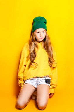 Bir portre studio poz parlak rahat kıyafetler içinde güzel bir kız. Güzellik, moda çocuklar için.