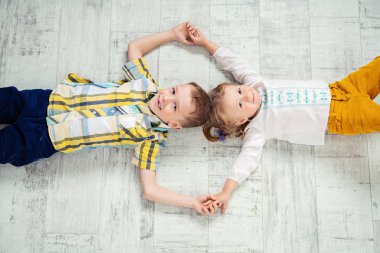 İki neşeli çocuklar yere yalan söylüyorsun. Çocuklar için moda.