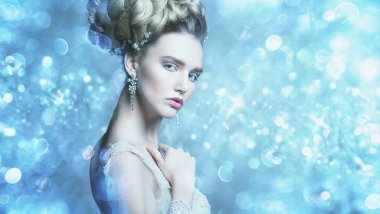 Stüdyoda gri arka plan üzerinde poz güzel soğuk bir Bayan portresi yakından. Güzellik, kozmetik, saç modeli.