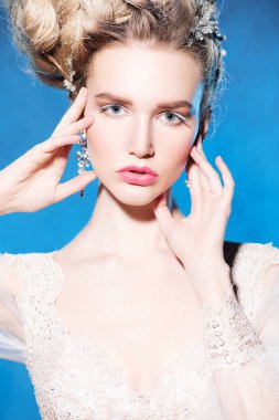 Stüdyoda mavi arka plan üzerinde poz güzel soğuk bir Bayan portresi yakından. Güzellik, kozmetik, saç modeli.