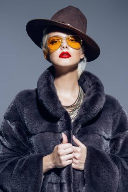 Çok güzel sarışın kadın lüks kürk manto ve şapka poz. Moda, güzellik. Stüdyo vurdu.