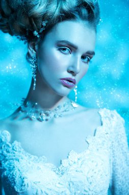 Stüdyoda mavi arka plan üzerinde poz güzel soğuk bir Bayan portresi yakından. Güzellik, kozmetik, saç modeli.