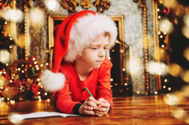 Noel Baba'ya bir mektup dileklerimle yazma genç bir çocuk portresi. Süslemeleri Noel ve yeni yıl için. Mucizeler için zaman.