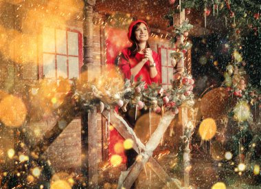 Evin verandada duran güzel bir kadın portresi Noel için dekore edilmiştir. Mutlu Noeller ve mutlu yeni yıl. Mucizeler için zaman.