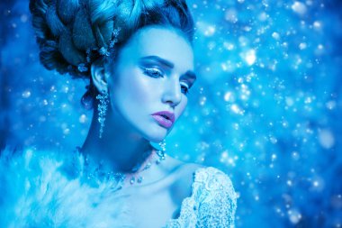 Stüdyoda mavi arka plan üzerinde poz güzel soğuk bir Bayan portresi yakından. Güzellik, kozmetik, saç modeli.