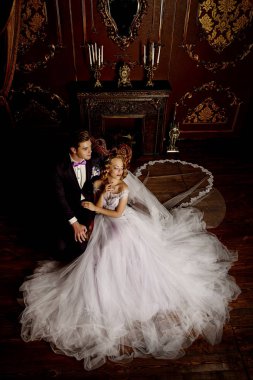 Güzel gelin ve damat bir lüks dairelerde ihale kucaklama oturuyor. Düğün moda.