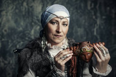 Yaşlı yerli kadın Ulusal kostüm reedpipe elinde tutmak.