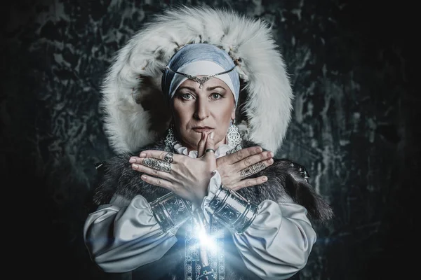 Portrait of an elderly native woman in a fur hood. A national costume. Mature lady.