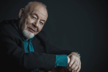 Siyah arka plan üzerinde gülümseyen bir adam portresi. Yaşlılık kavramı.