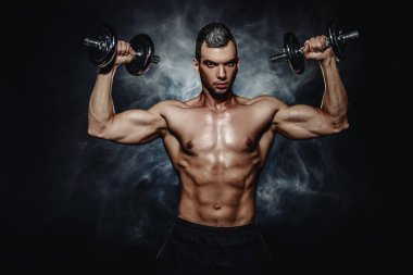 Kas acımasız adam dumbbells ile yapıyor. Sağlık ve spor kavramı.