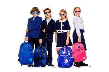 Grup modern çocuk okul üniforması ve güneş gözlüğü poz. Okul moda. Beyaz arka plan üzerinde izole. Tam uzunlukta portre. 