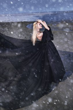 Tam uzunlukta portre güzel bir Gotik kadının uzun siyah elbise poz açık. Güzellik, moda.