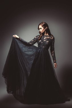 Bir kuzgun harabeye ile güzel bir esmer bayan. Gece elbisesi. Moda, güzellik.