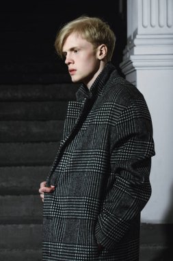 Sarı saçlı bir şehir sokakta duran bir ekose ceket giyiyor ile yakışıklı bir genç adam portresi. Erkek güzellik ve sağlık. Güzellik, şehir moda.