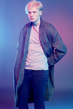 Stüdyoda gri arka plan üzerinde poz yakışıklı bir genç adam sarı saçlı bir ekose ceket giyen portresi. Erkek güzellik ve sağlık.