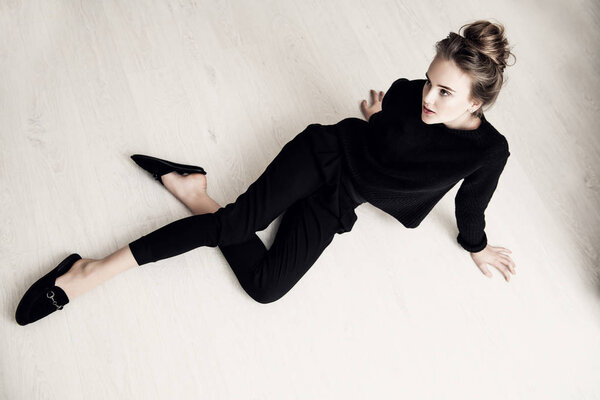 Портрет милой девочки-подростка, сидящего на полу в комнате. Красота, мода
.