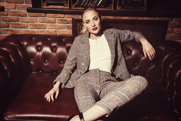 Sexy woman in a elegant suit posing in luxurious vintage interior. Full length portrait. Beauty, fashion.