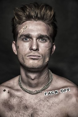 Kötü çocuk kavramı. Kötü biri edepsizlik ve saldırganlık siyah arka plan üzerinde gösterilen yakın çekim portre. Rocker, serseri. 