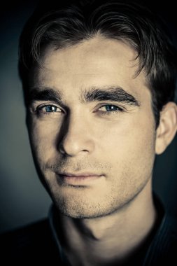 Yakın çekim yakışıklı bir genç adam siyah arka plan üzerine portresi. Erkek güzellik. Erkek Sağlığı.