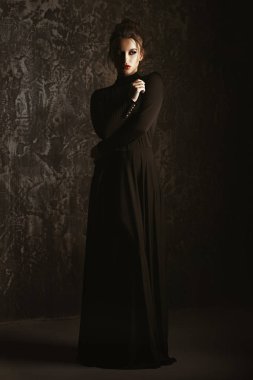Siyah uygun uzun elbise giyen zarif genç kadın. Güzellik, moda kavramı. Stüdyo vurdu.