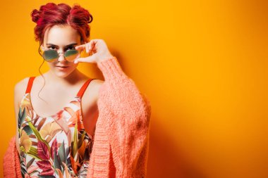 Sarı arka plan üzerinde parlak kıyafetleri pembe saçlı güzel kız. Parlak stil, moda.