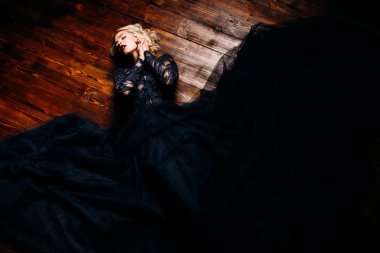 Güzel bir sarışın Bayan yerde yatıyor. Gece elbisesi. Moda, güzellik.