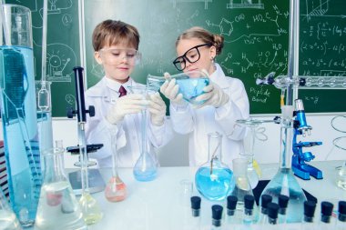 İki çocuk bilim adamları deneyler laboratuvarda yapma. Eğitim kavramı. Erken çocuk gelişimi.