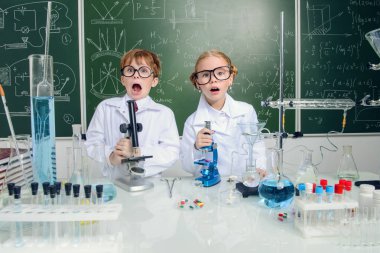 Komik kız ve erkek bilim adamları laboratuarda deney yapıyorlar. Eğitim kavramı. Erken çocuk gelişimi.