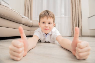 Hoş çocuk yerde yatarken ve kameraya gülümseyen. Çocukluk. Çocuk moda.