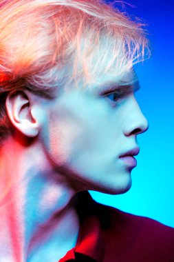 Yakın çekim portre sarışın saç stüdyoda ışık arka plan üzerinde poz ile yakışıklı bir genç adam. Erkek güzellik ve sağlık.