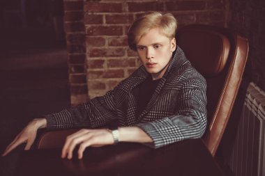 Bir caf bir masada kareli ceket sarışın bir adam portresi. Erkek güzelliği, moda. 