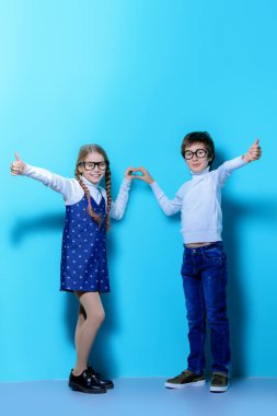 Mutlu gözlüklü çocuk mavi arka plan üzerinde poz olan. Mutlu çocukluk. Bahar tatil.