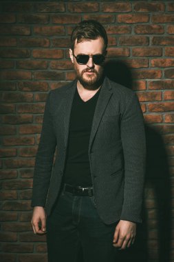 Siyah gömlek ve güneş gözlüğü takan yakışıklı sakallı adam. Erkek moda.