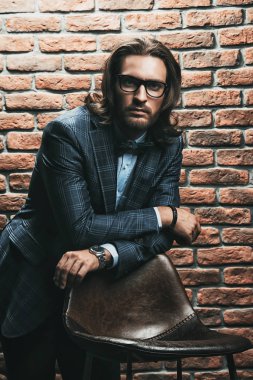 Heybetli bir çatı katı iç şık elbiseli Genç adam. Erkek güzelliği, moda. İş tarzı.