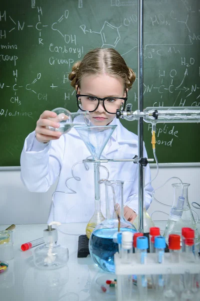 Ciddi küçük kız laboratuvarda deneyler yapıyor. Bilim ve eğitim.